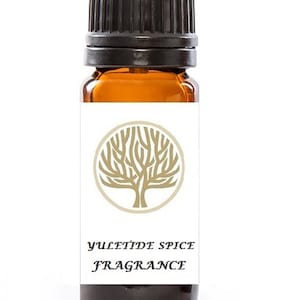 Może przedstawiać: Mała, bursztynowa butelka ze szklanym korkiem. Butelka ma białą etykietę z złotym logo drzewa i tekstem "YULETIDE SPICE FRAGRANCE".