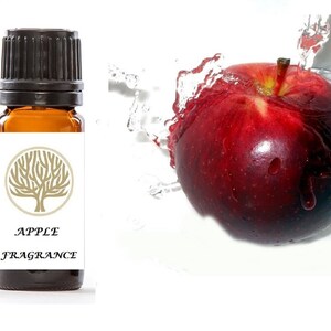 May include: A small brown glass bottle with a black cap, labeled "APPLE FRAGRANCE" and a gold tree design. A red apple with water droplets is shown in the background.