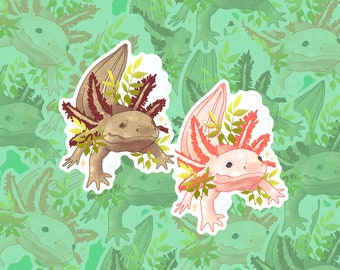 May include: Two axolotl stickers with leafy details. One axolotl is brown with red gills and the other is pink with red gills.