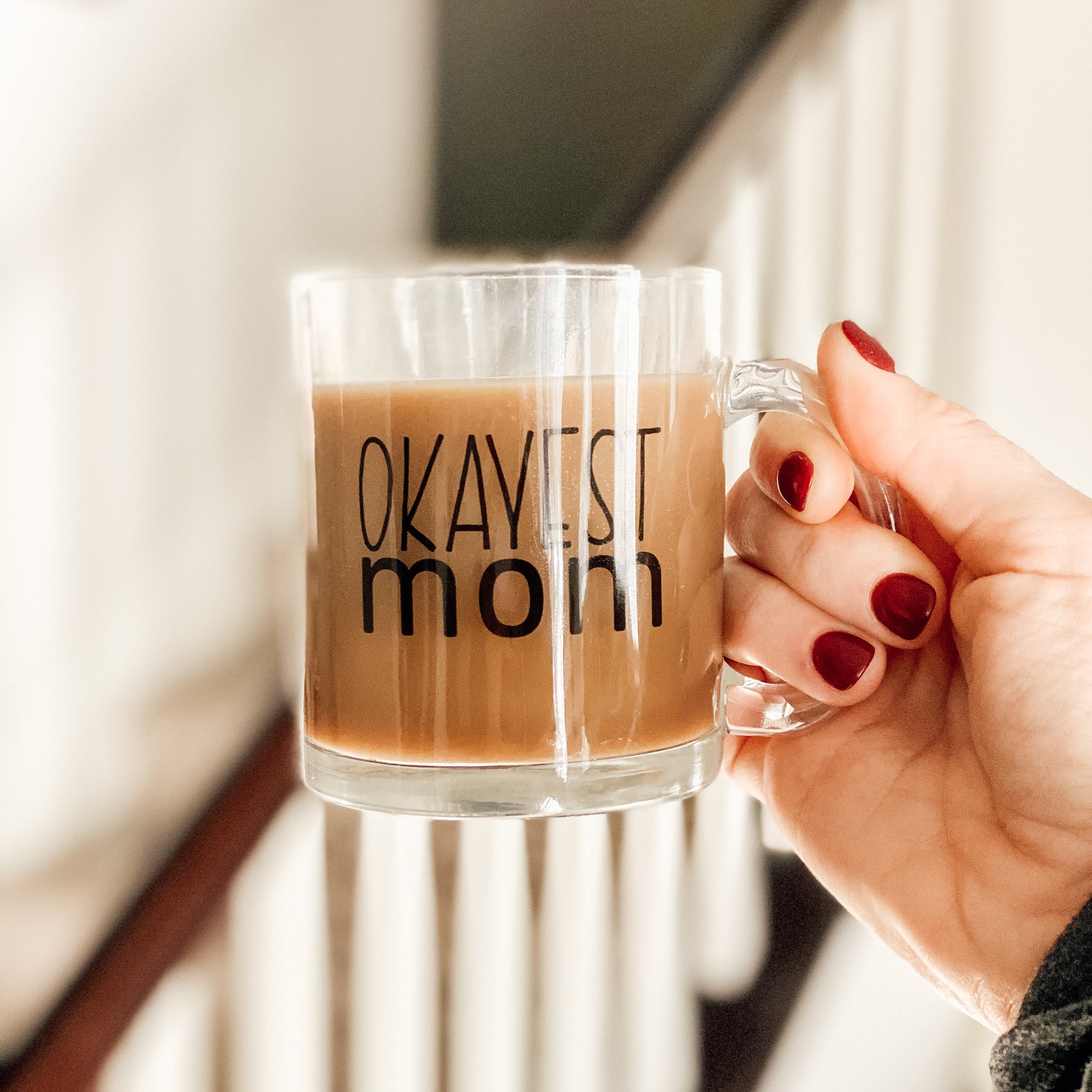 okayest mom glass mug with coffee and hand holding