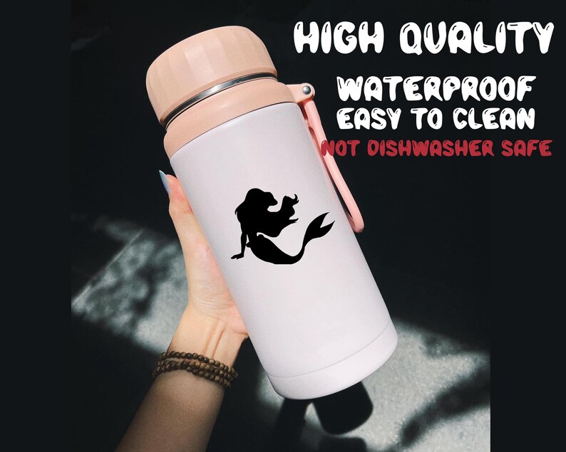 May include: White insulated water bottle with a pink lid and a black silhouette of a mermaid on the side. The bottle has the text "HIGH QUALITY WATERPROOF EASY TO CLEAN NOT DISHWASHER SAFE" printed on the side.