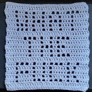 Puede incluir: Un cuadrado blanco tejido a crochet con un patrón repetitivo de agujeros. El cuadrado tejido a crochet está hecho con un punto bajo.