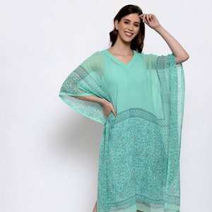 May include: A turquoise blue, sheer, printed kaftan with a V-neckline and 3/4 sleeves. The kaftan has a floral pattern and a border around the hem.