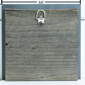 Peut inclure: Une pancarte en bois de 14 cm par 14 cm avec une finition grise vieillie. La pancarte a une boucle de suspension en m&eacute;tal sur le dessus.