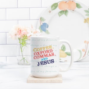 May include: White ceramic coffee mug with a colorful graphic that reads "A few of my favorite things: Coffee, Oxford Commas, and Jesus".