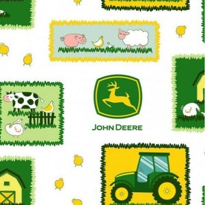 May include: A white background with green, yellow and blue squares featuring farm animals, a John Deere logo and a green tractor. The animals include a cow, pig, sheep and chickens.