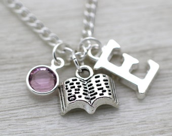 Può includere: Collana d'argento con un ciondolo a forma di libro, un ciondolo di cristallo rosa e un ciondolo con la lettera E.