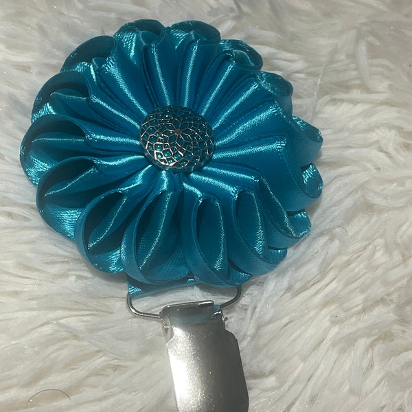 Folded rosette style flower made with blue and teal ribbon, centre piece, Dog Show exhibitor number ring clip with pinback finishing