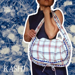May include: A white and red plaid shoulder bag with blue trim. The bag has a curved shape and long straps. The text "KASHI" is at the bottom of the image, and "pdf sewing pattern" is at the top.