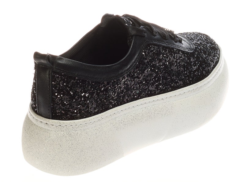 May include: Black glitter sneakers with a white platform sole. The sneakers have a lace-up closure.