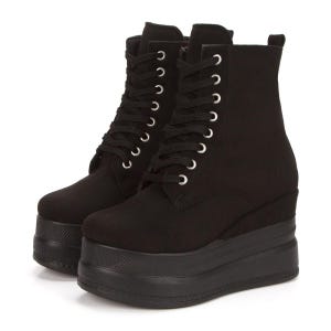 May include: Black platform boots with a lace-up fastening. The boots feature a chunky, textured sole and a wedge heel. The laces are threaded through silver eyelets. The boots are made from a soft, suede-like material.