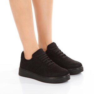 May include: A pair of black suede low-top sneakers with white laces. The sneakers have a thick white sole and a perforated design on the toe.