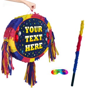 May include: A vibrant, round piñata with the text "YOUR TEXT HERE" in gold lettering. The piñata features red, blue, and yellow fringe. A matching stick and rainbow eye mask are included. Party supplies.