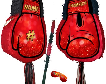 May include: Two red boxing glove shaped pinatas with black and white fringe. One pinata says "CHAMPION" and the other says "NAME #". A black and red stick and a black eye mask are included.