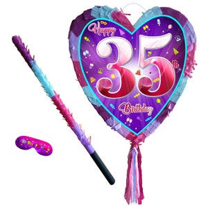 May include: A heart-shaped purple and pink pinata with the number 35 and the text "Happy 35th Birthday". The pinata comes with a stick and a blindfold.