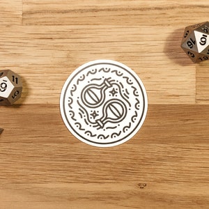 May include: A white sticker with a black line drawing of two potion bottles with stars and wavy lines around them. The sticker is on a wooden surface with three metal dice.