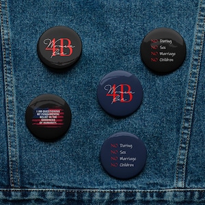 May include: Four black and blue button pins with red text. One pin says "Women for", another says "I am questioning my fundamental belief in the goodness of humanity." The other two pins say "NO Dating, NO Sex, NO Marriage, NO Children."