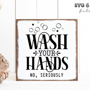 May include: A square wooden sign with a white painted center and dark wood edges. The sign features black text that reads "WASH YOUR HANDS NO, SERIOUSLY" with a graphic of bubbles above the text. The design is presented as a digital file.