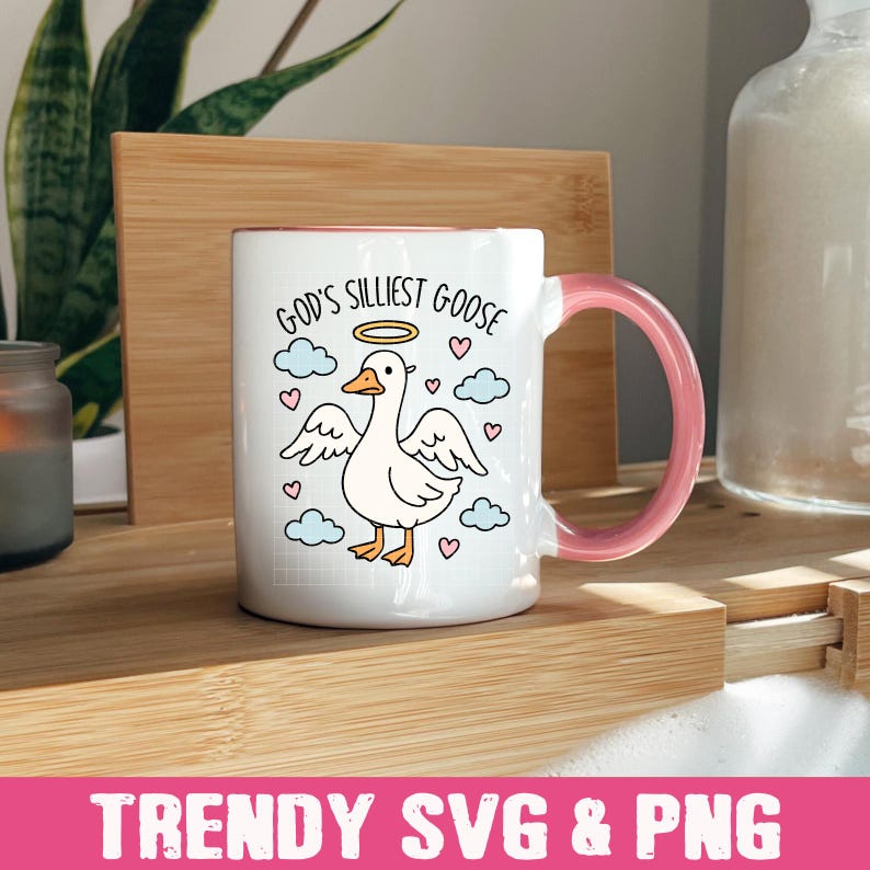 Peut inclure: Mug en c&eacute;ramique blanche avec une anse et un bord roses. La tasse pr&eacute;sente un dessin d'oie avec un halo, entour&eacute;e de nuages et de c&oelig;urs, et le texte "God's Silliest Goose". Le bas de l'image porte le texte "TRENDY SVG & PNG".