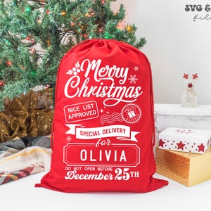 May include: A red fabric drawstring sack featuring white printed text that reads Merry Christmas, Nice List Approved, North Pole Express, Special Delivery for Olivia, and Do Not Open Before December 25th, with snowflake and holly graphics.