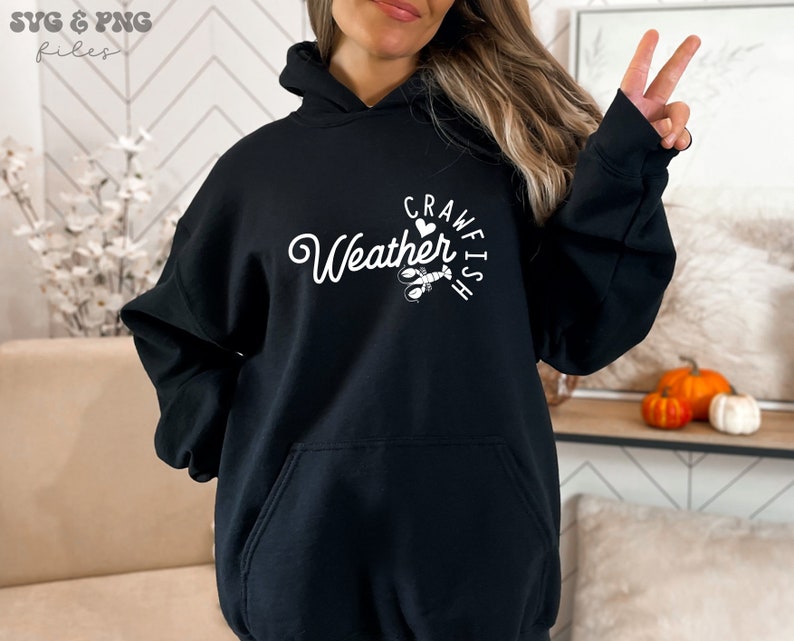 May include: Black hooded sweatshirt with white text that reads "Crawfish Weather" with a heart and a crawfish illustration.
