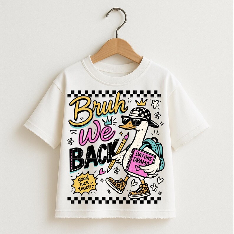 May include: White t-shirt featuring a cartoon goose wearing sunglasses, a checkered hat, and leopard print shoes. The goose carries a backpack and a notebook that says "Day One Drama." The shirt has the words "Bruh We Back" in colorful text.