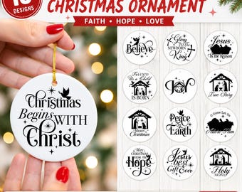 May include: A set of 15 round white Christmas ornaments featuring black text and nativity silhouettes. Designs include phrases like Christmas Begins With Christ, Glory To The Newborn King, and Jesus Is The Reason, with stars and religious imagery.
