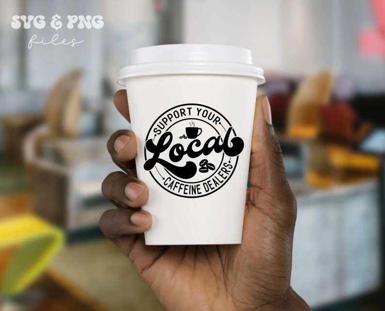 May include: A white to-go coffee cup with a black circle design that says "Support Your Local Caffeine Dealers" with a stylized coffee cup and coffee beans inside the circle.