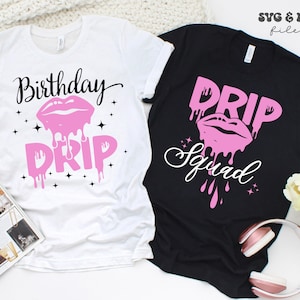 May include: Two white t-shirts with black text and pink graphic designs. The first shirt says "Birthday Drip" with a pink dripping lip design. The second shirt says "Drip Squad" with a pink dripping lip design.