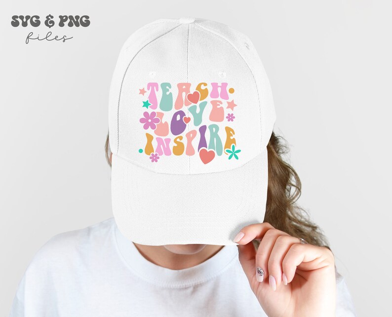 Peut inclure: Casquette de baseball blanche avec un design r&eacute;tro color&eacute; qui dit "Teach Love Inspire".