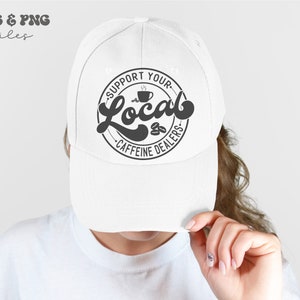 May include: White baseball cap with a black and white graphic that says "Support Your Local Caffeine Dealers" with a coffee cup and coffee beans in the design.
