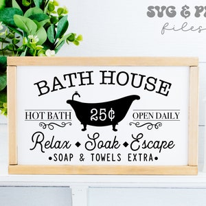 May include: A rectangular wooden framed sign with a white background and black text that reads BATH HOUSE, HOT BATH 25&cent;, OPEN DAILY, Relax, Soak, Escape, and SOAP & TOWELS EXTRA, featuring a black silhouette of a clawfoot bathtub in the center.