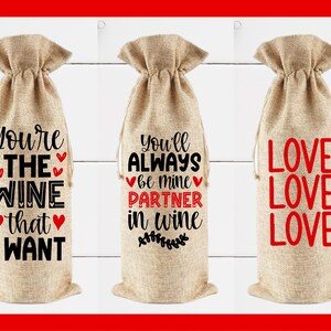May include: Three burlap wine bottle gift bags with different sayings printed on them. The first bag says "You're the wine that I want". The second bag says "You'll always be mine partner in wine". The third bag says "Love Love Love".
