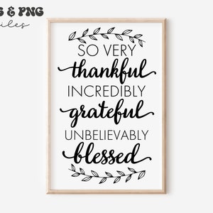 May include: A rectangular wall art print in a light wood frame featuring black text on a white background that reads: SO VERY thankful INCREDIBLY grateful UNBELIEVABLY blessed, accented by a black line-art leaf branch at the top and bottom.