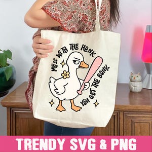 Peut inclure: Sac fourre-tout cr&egrave;me avec un dessin de canard tenant une batte de baseball rose. Le texte dit "MESS WITH THE HONK YOU GET THE BONK". Le bas du sac affiche le texte "TRENDY SVG & PNG".