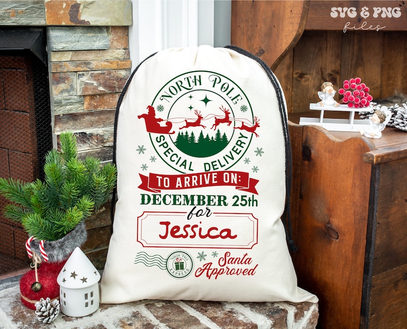 May include: A cream-coloured drawstring sack featuring a red and green graphic of Santa Claus in a sleigh with reindeer. The text reads North Pole Special Delivery, To Arrive On: December 25th for Jessica, and Santa Approved with a postmark stamp.