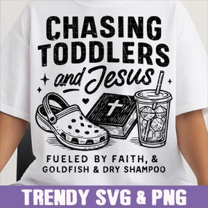 May include: White t-shirt with a black graphic. The graphic includes the text "CHASING TODDLERS and Jesus" with a shoe, book, and drink illustration. Below it reads "FUELED BY FAITH, & GOLDFISH & DRY SHAMPOO".