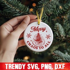May include: White ceramic Christmas ornament with red text that reads "Merry Chaos to All" and a red stylized Christmas tree design.