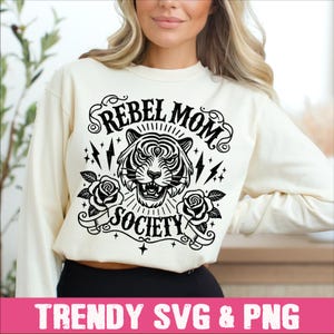 May include: A white sweatshirt with a black graphic design featuring a tiger with the text "Rebel Mom Society".