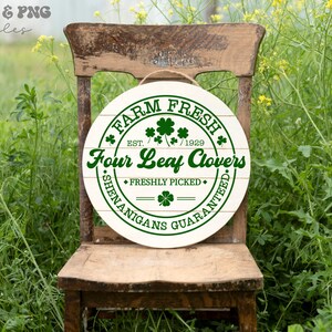 May include: A white round wooden sign with green text that reads "FARM FRESH EST. 1929 Four Leaf Clovers FRESHLY PICKED SHENANIGANS GUARANTEED". The sign has a rustic woodgrain pattern and is decorated with green four-leaf clover designs.
