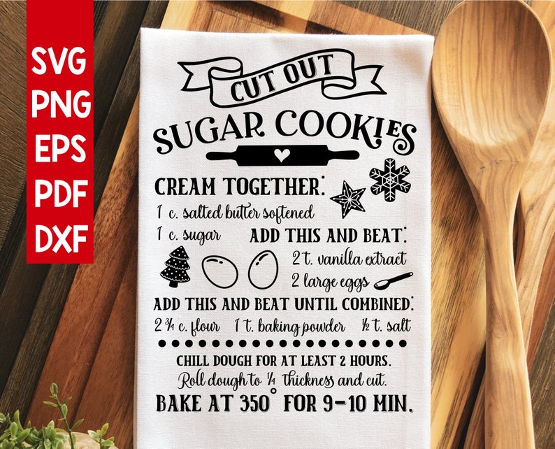 May include: A white tea towel with black text that reads "Cut Out Sugar Cookies". The text includes a recipe for sugar cookies with instructions to cream together butter and sugar, add vanilla extract and eggs, and then add flour, baking powder, and salt. The recipe also includes instructions to chill the dough for at least 2 hours, roll the dough to 1/4 inch thickness, and bake at 350 degrees Fahrenheit for 9-10 minutes.