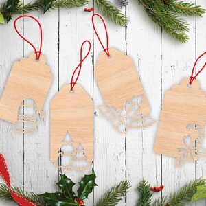 May include: Four light-coloured wooden gift tags with red string loops. Each tag features a unique laser-cut design at the bottom: a mitten, two pine trees, a holly sprig with berries, and a candy cane with a bow, all with a smooth wood grain finish.