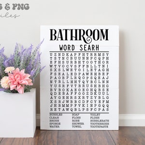 May include: A white rectangular wooden sign featuring the black text BATHROOM WORD SEARH, a grid of letters, and a list of words including BUBBLES, SOAP, TOILET, CLEAN, FLOSS, FLUSH, BRUSH, ROBE, BUBBLEBATH, SPONGE, SHOWER, TOOTHBRUSH, WATER, TOWEL, TOOTHPASTE.