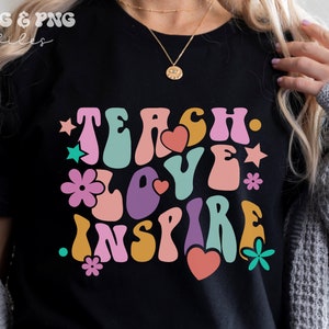 Peut inclure: T-shirt noir avec un graphique de style r&eacute;tro qui dit "Teach. Love. Inspire." en lettres color&eacute;es et ondul&eacute;es. Le graphique est entour&eacute; de petits c&oelig;urs, &eacute;toiles et fleurs.