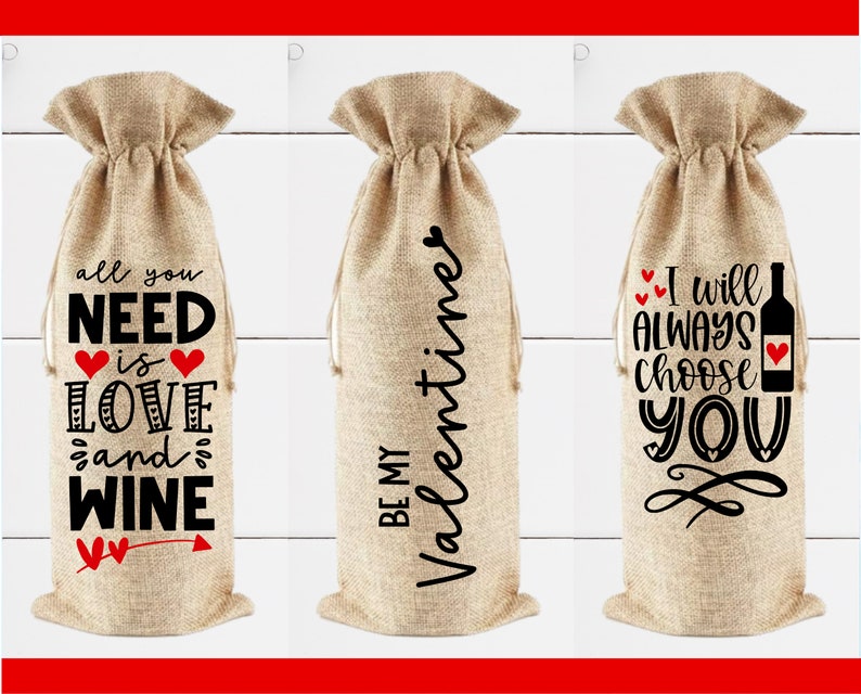 May include: Three burlap wine bottle bags with different Valentine's Day themed sayings. The first bag says "all you need is love and wine". The second bag says "Be my Valentine". The third bag says "I will always choose you".