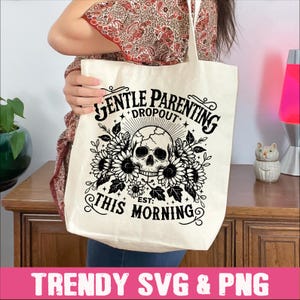 May include: A white tote bag with a black graphic design. The design features a skull with flowers and the text "Gentle Parenting Dropout Est: This Morning".