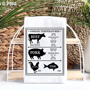 May include: A white kitchen towel with black text and illustrations of a cow, pig, chicken, and fish. The text reads "Cooking Temperatures" and lists the internal temperatures for different types of meat, including rare, medium rare, medium, and well done.