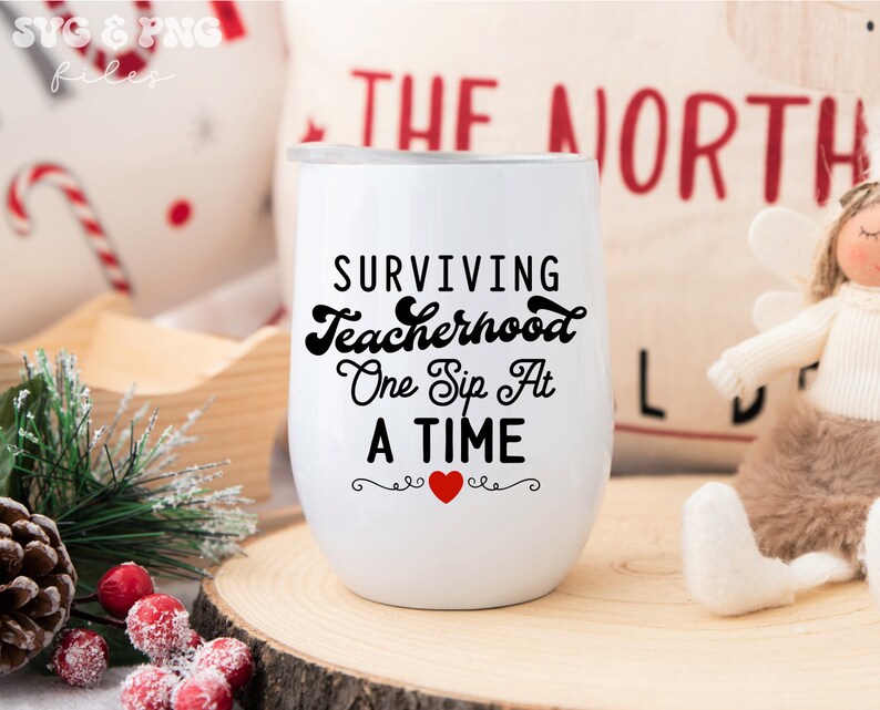 May include: White wine tumbler with black text that reads "Surviving Teacherhood One Sip At A Time" with a red heart in the center.