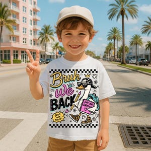 May include: A white t-shirt with the text "Bruh We Back" and a cartoon goose wearing sunglasses, a backpack, and leopard print shoes. The shirt also has the text "Day One Drama" and "good luck teach". The child is wearing a beige baseball cap.