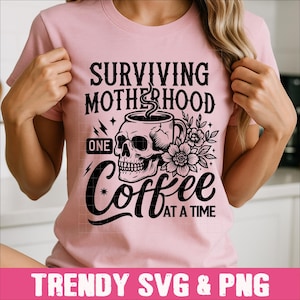 May include: Pink t-shirt with a black and white graphic design. The graphic features a skull holding a coffee cup with the text "Surviving Motherhood One Coffee At A Time".